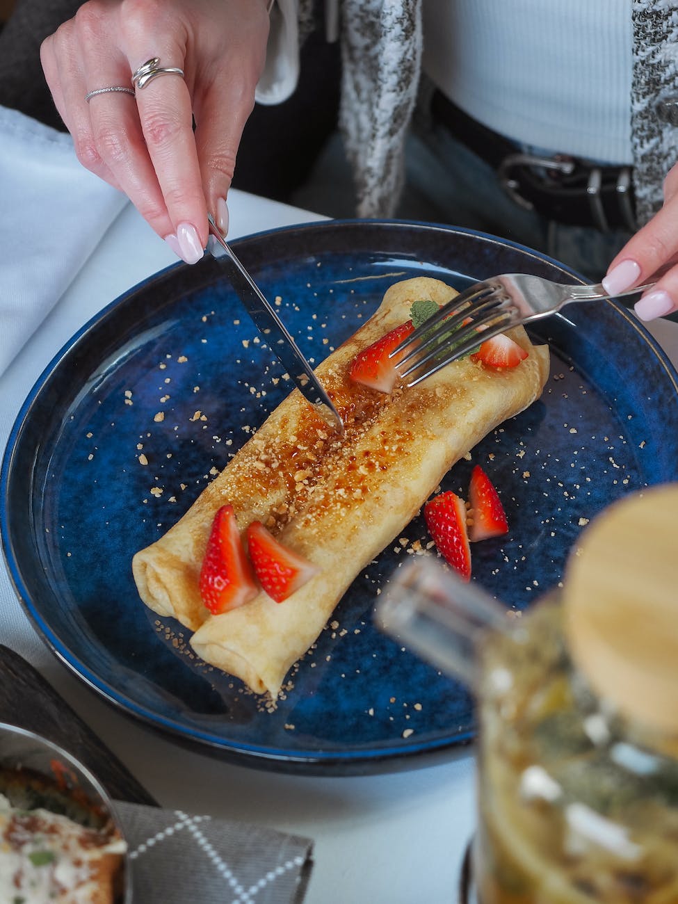 pexels-photo-15661097 - The Paris Post woman eating crepes with strawberries