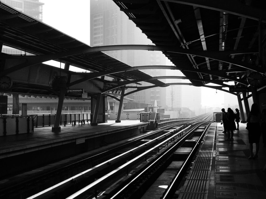 silhouettes of anonymous people standing on railway platform