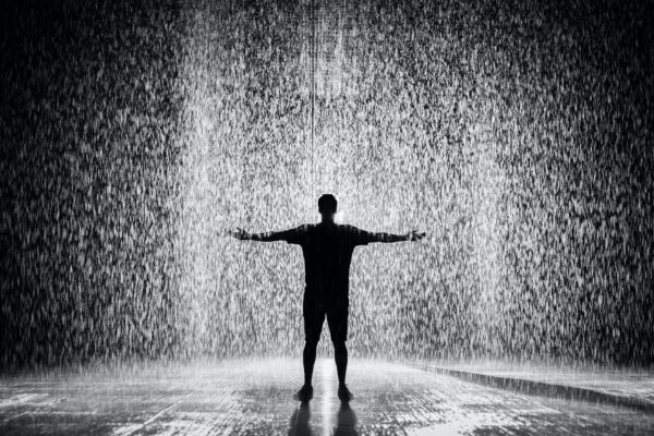 silhouette and grayscale photography of man standing under the rain Send Down The Rain