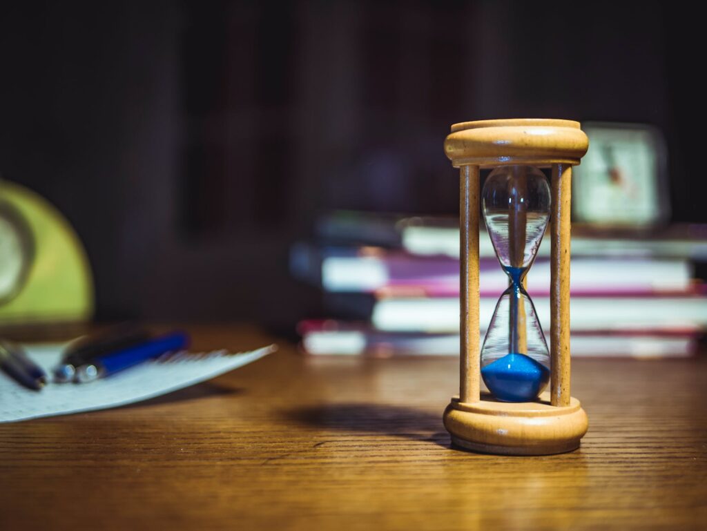 hourglass on brown wooden frame Time Will Tell
