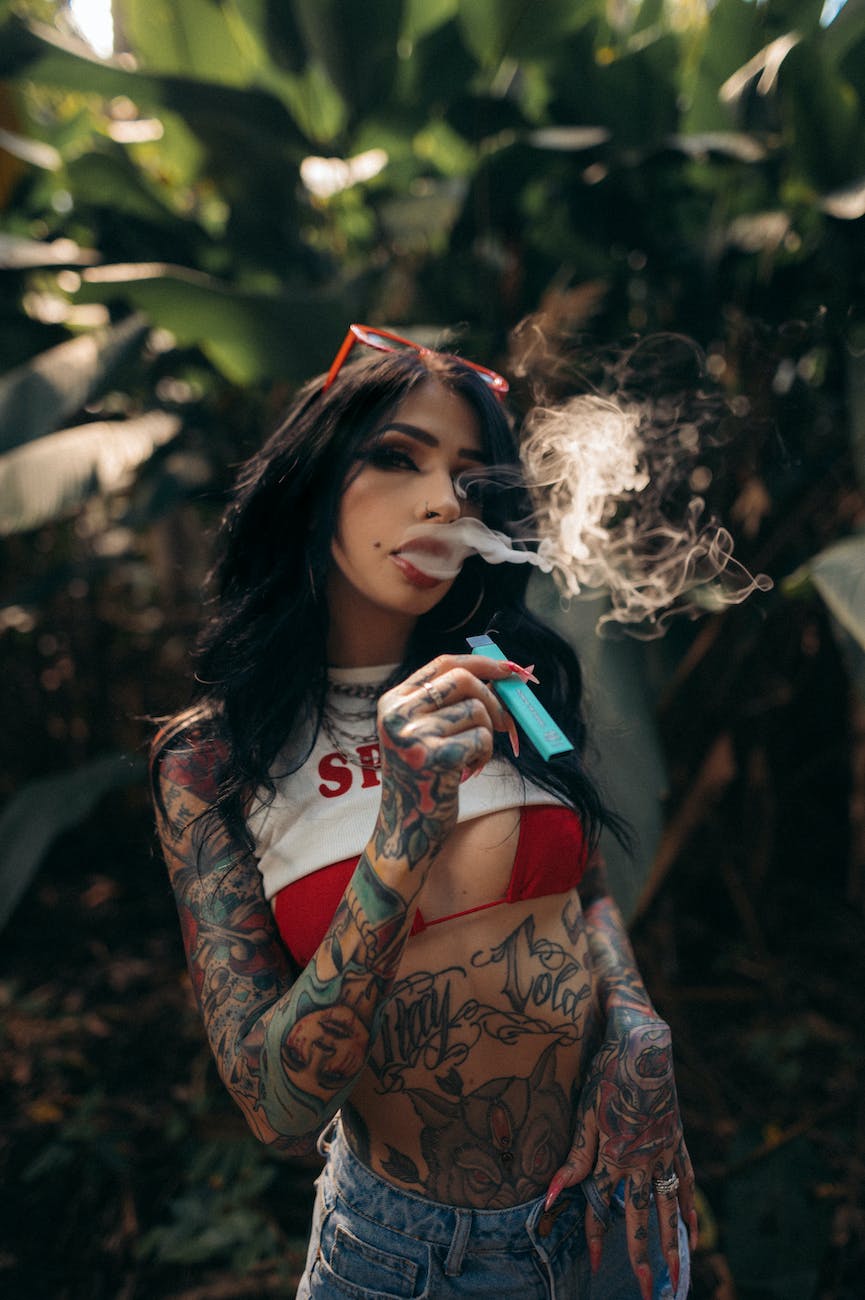 pexels-photo-11921813 - The Paris Post woman in black and red floral long sleeve shirt smoking | E-Cigarette advertising and using is danger and cause cancer | India Banned E-Cigarette