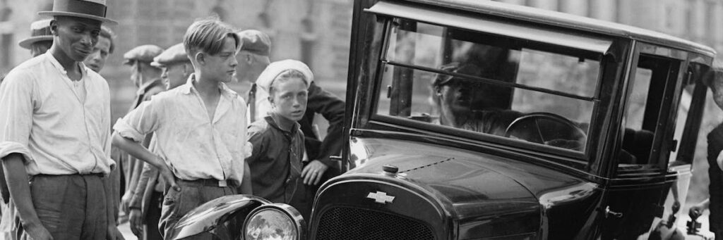 Road safety week: grayscale photo of people standing near the wrecked vintage car