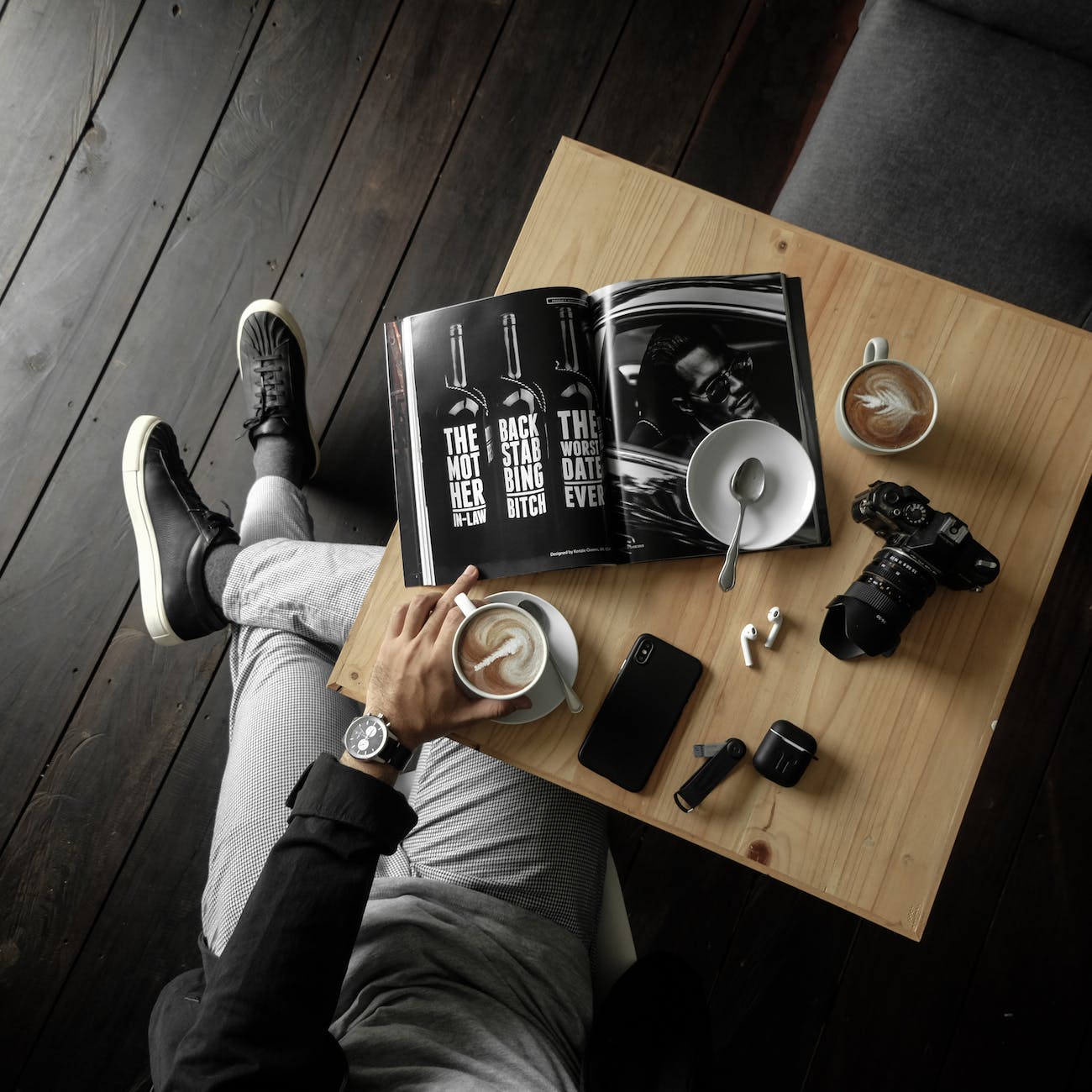 pexels-photo-3098619 - The Paris Post top view of a table with man holding a cup of latte with a magazine camera cellphone and other personal effects | Technology Guest posting | Photo by Drew Williams on Pexels.com