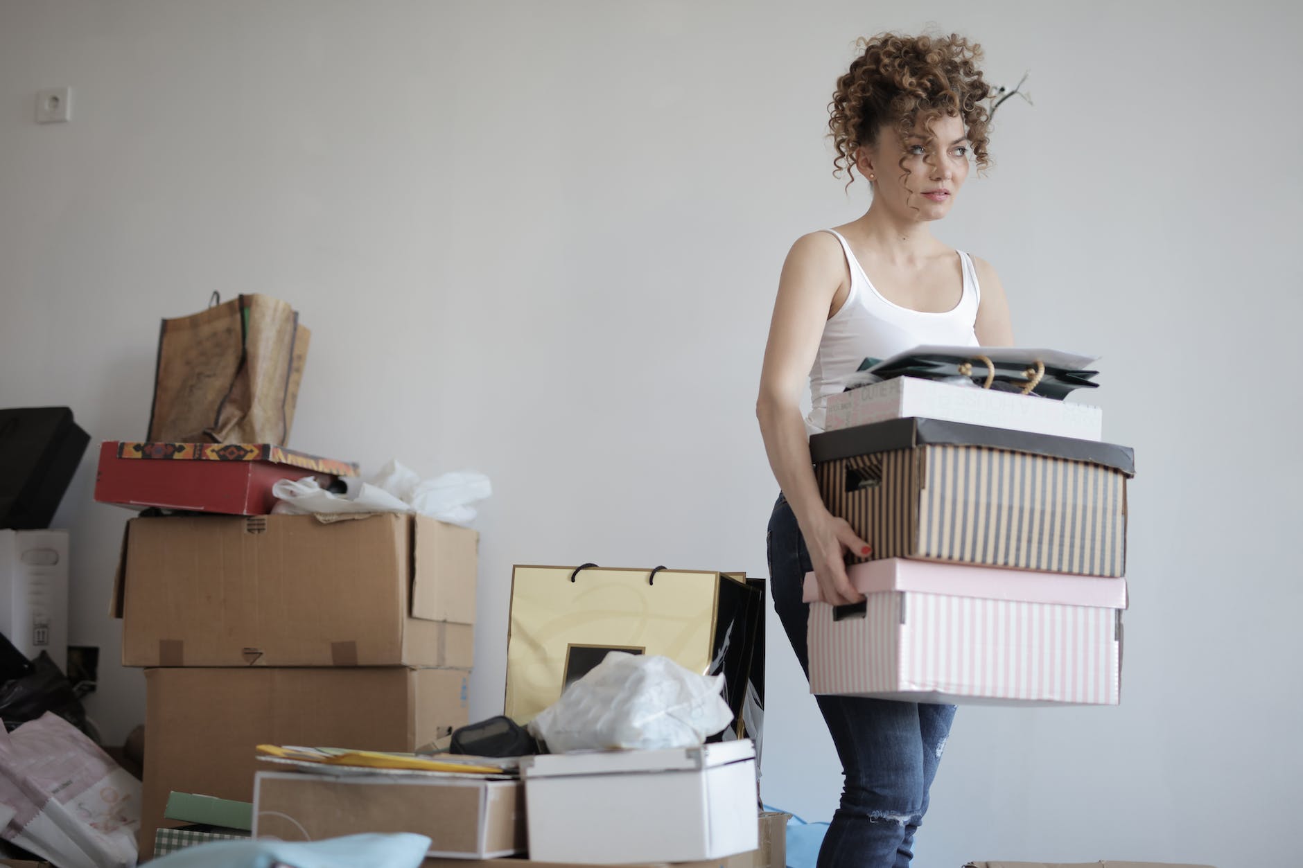 pexels-photo-3791617 - The Paris Post concentrated woman carrying stack of cardboard boxes for relocation | Bridge Mortgage: Change Your House Before Selling Yours