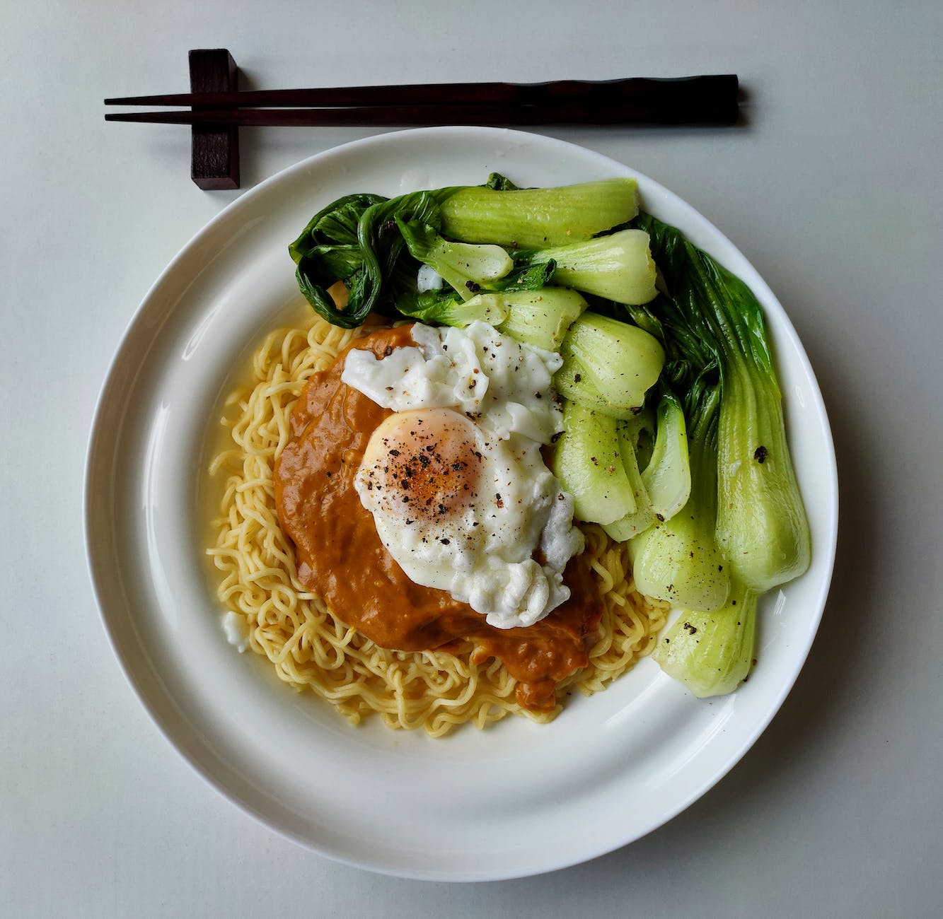pexels-photo-4150125 - The Paris Post delicious noodles with bok choy and fried egg on plate | Black pepper benefits: Best health in a modern lifestyle and using it on modern food as well. Photo by Syed Muhammad Afifi on Pexels.com