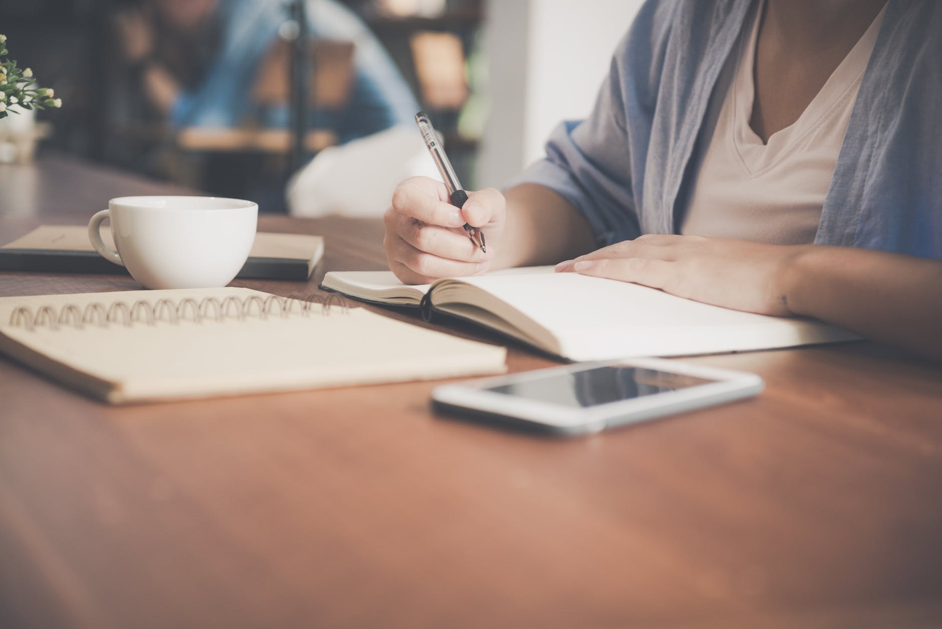 pexels-photo-733856 - The Paris Post woman writing on a notebook beside teacup and tablet computer | What is guest posting?