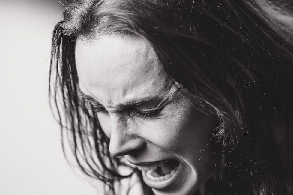 dramatic black and white emotional expression portrait: This essay explores effective anger management techniques and the rising impact of digital disorders. It discusses causes, symptoms, and evidence-based strategies for emotional regulation, along with practical solutions for overcoming smartphone and internet addiction to promote mental well-being.